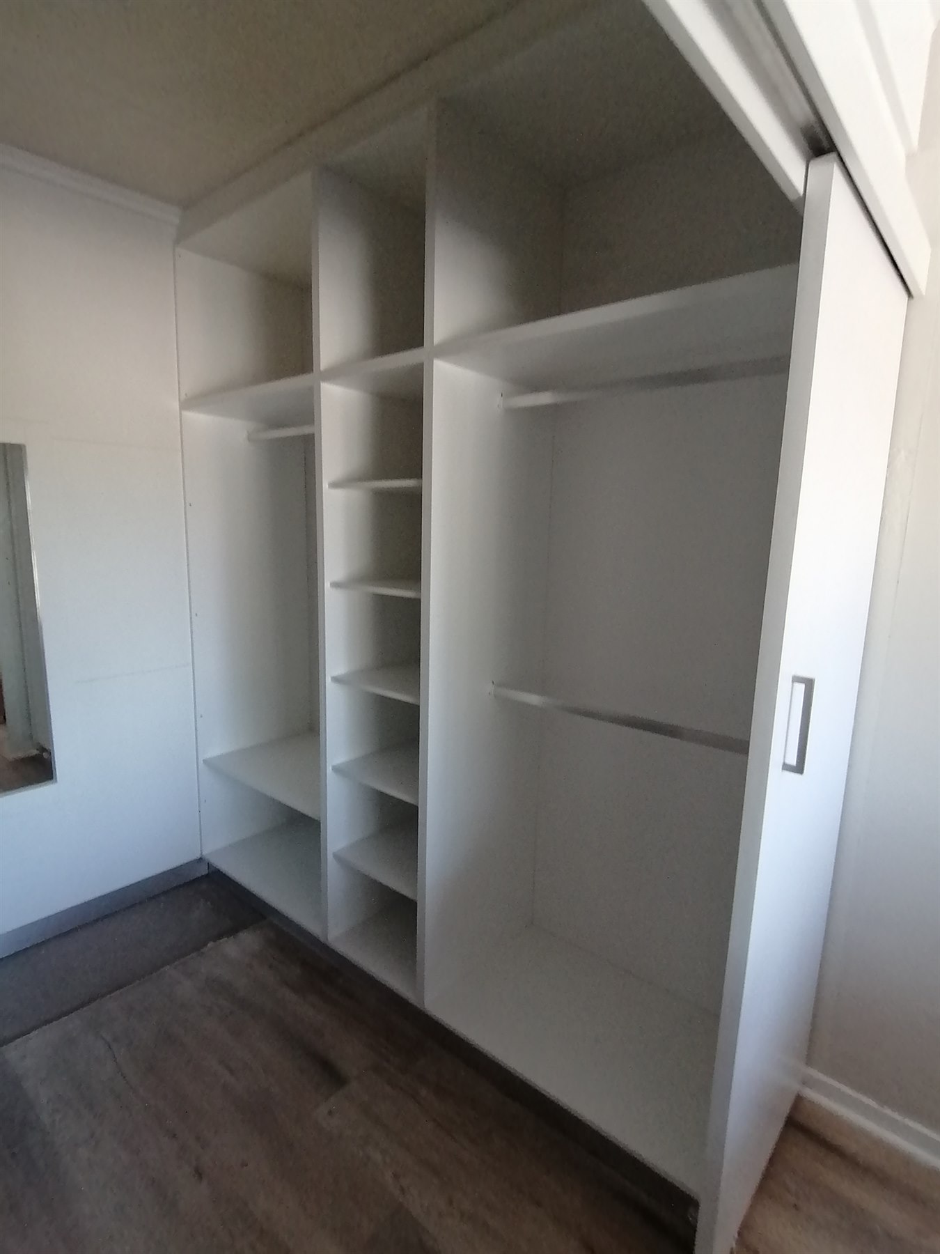 View this project in the gallery White walk-in wardrobe shelving and sliding cupboard doors